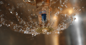 a close up of a fire sprinkler head with water